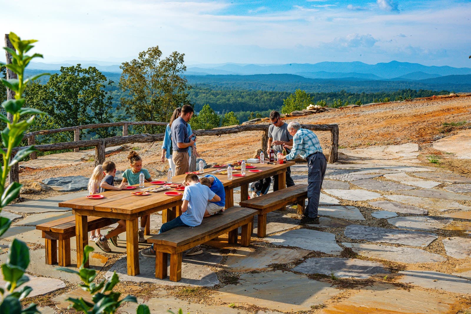 Adults and children at a picnic table with Blue Ridge views at Longview Carolina